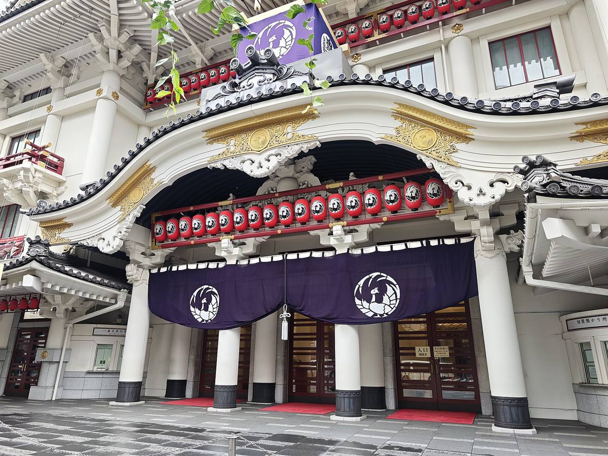 Inngangspartiet til Kabuki-za i Tokyo med svungent tak, forgylte utskjæringer, rader av røde papirlykter og lilla forheng over dørene
