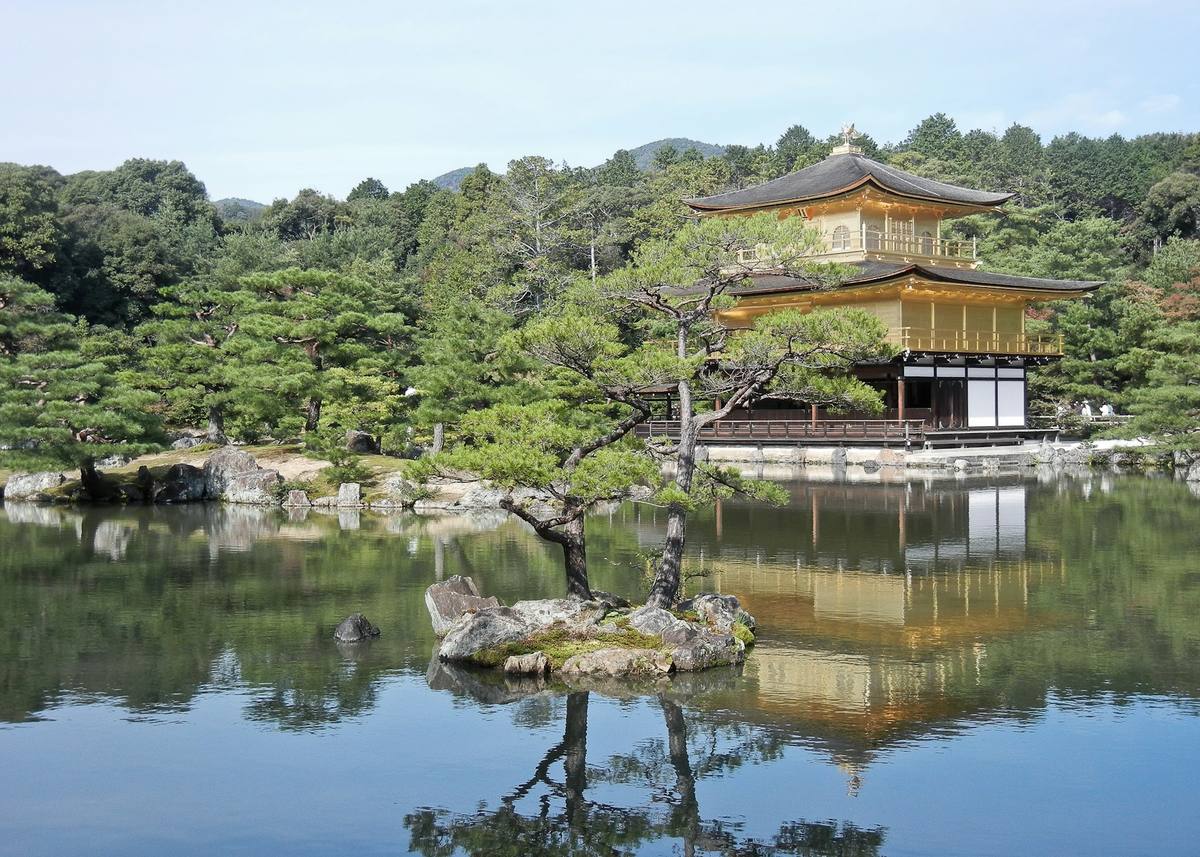 Den gullbelagte paviljongen Kinkaku-ji speiler seg i dammen Kyoko-chi, med formklipte furuer og en liten steinøy i forgrunnen