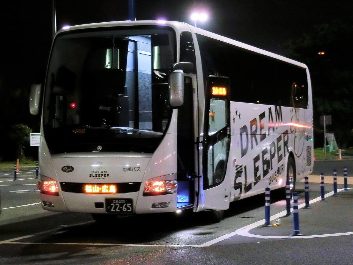 Hvit japansk nattbuss med teksten Dream Sleeper på siden, fotografert om kvelden med opplyst destinasjonsskilt på japansk foran