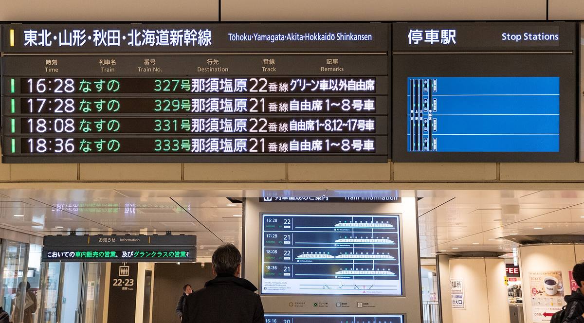 Avgangstavle for shinkansen med togtider, destinasjoner og vognnummer på japansk og engelsk