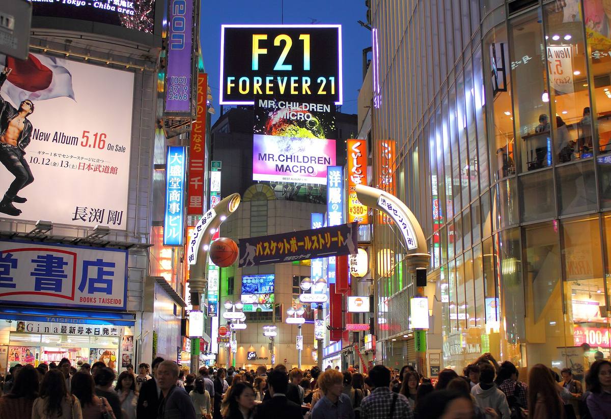 Center Gai i Shibuya om kvelden, en smal gate mellom fasader dekket av lysende skilt og reklame
